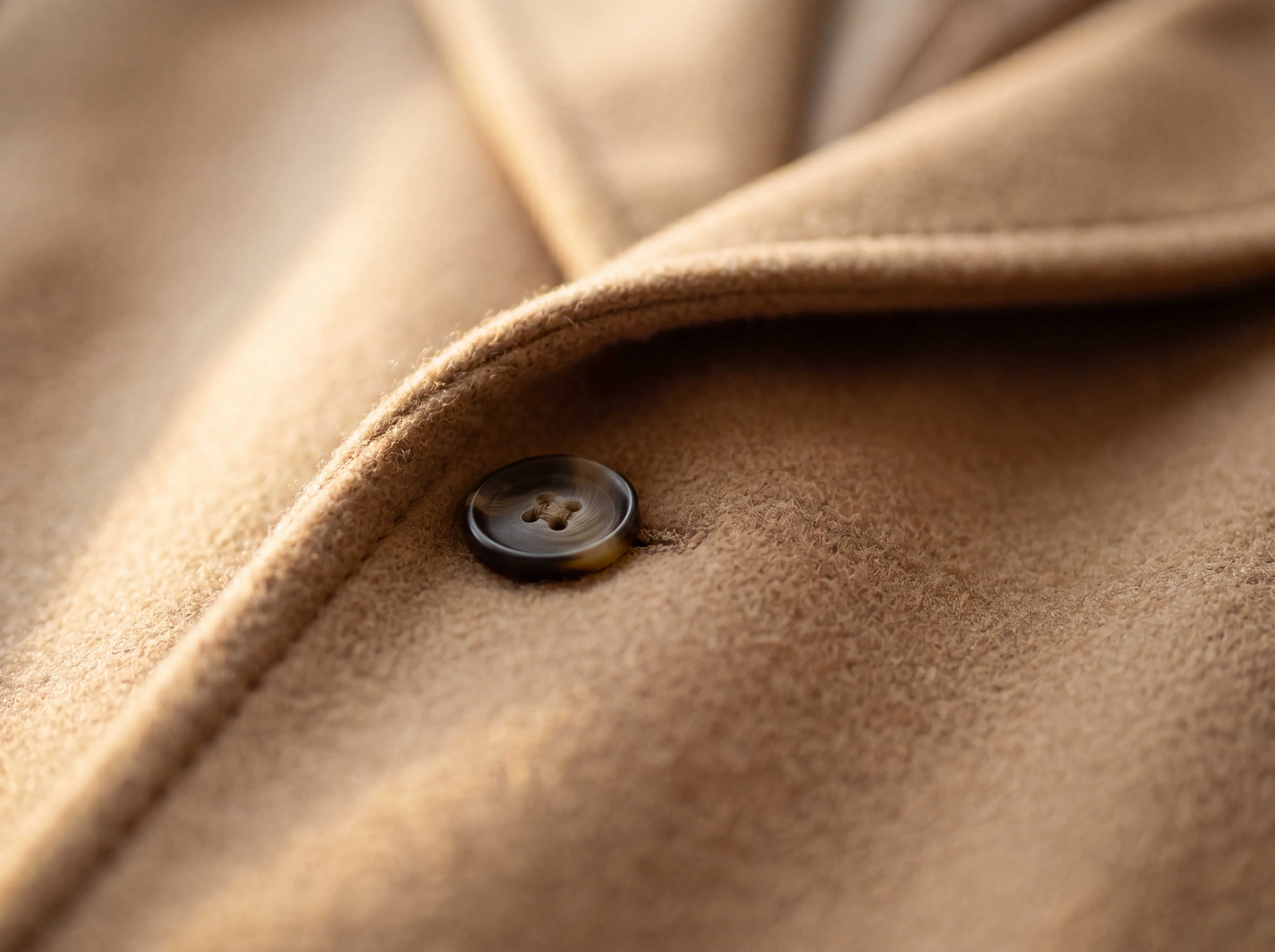A macro detail of a camel wool coat lapel and weave
